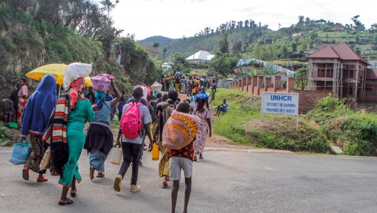 Des réfugiés de la République Démocratique du Congo portent leurs effets personnels en passant près des bureaux du HCR au camp de réfugiés de Kiziba, au Rwanda, le 21 février 2018. © Jean Bizimana / REUTERS