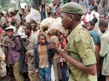 Un rebelle zaïrois de l'armée de Laurent-Désiré Kabila, soutenue par le FPR rwandais, passe devant une foule de réfugiés hutus rwandais dans le camp de Biaro, près de Kisangani le 8 mai 1997. AFP / A. Senna