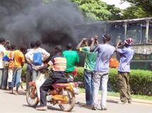 Un attroupement devant un bus en flammes à Ouagadougou, le 16 avril 2011. AFP PHOTO / AHMED OUOBA