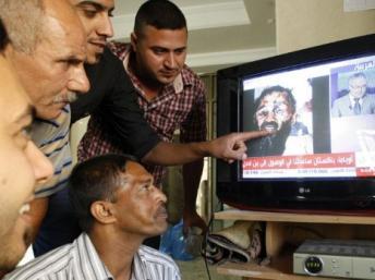 A Bagdad, des Irakiens regardent la chaîne de télévision Al-Arabiya qui diffuse des images du cadavre d'Oussama ben Laden, le 2 mai 2011. PHOTO/SABAH ARAR