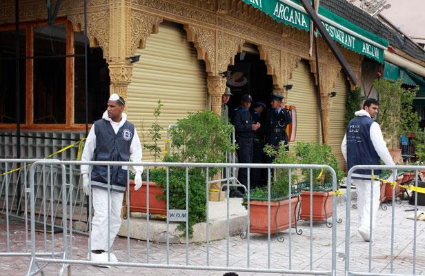 Des enquêteurs travaillent sur la scène de l'explosion qui a eu lieu au café Argana, situé sur laplace Jamaa el-Fnaa, à Marrakech, le 29 avril 2011. REUTERS/YOUSSEF BOUDLAL