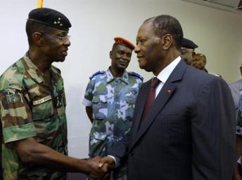 Le président élu Alassane Ouattara salue le général Philippe Mangou à l'hôtel du Golf à Abidjan où une cérémonie «d'allégeance» des responsables militaires s'est tenue, 12 avril 2011. AFP/Aristide Bodegla