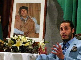 Saadi Kadhafi posant devant le portrait de son père.