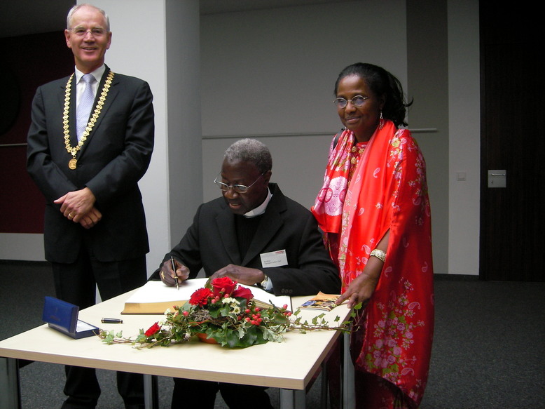 Le cardinal Sarr signe le livre d'or : le maire de la ville Dr. Siegfried Balleis, Son Emeinence le Cardinal Sarr, Dr. Pierrette Herzberger-Fofana