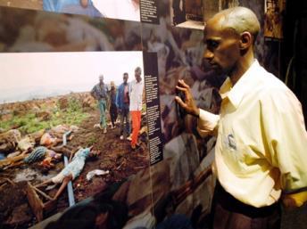 Un survivant du génocide et guide du mémorial regarde un panneau de photos du génocide, à Kigali. AFP/Gianluigi Guercia