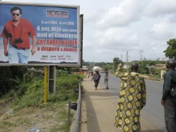 Affiche de Guy-André Kieffer apposée sur un panneau publicitaire sur une route d’Abidjan, le 15 avril 2010. AFP/ ISSOUF SANOGO