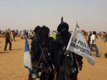 «La paix est un comportement» dit le drapeau que tiennent ces ex-combattants touaregs, au Forum pour la paix et le développement, le 22 Janvier 2012, à Arlit, au Niger. AFP PHOTO / Boureima HAMA