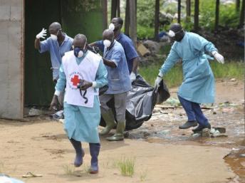 Des membres de la Croix-Rouge en Côte d'Ivoire ramassent des cadavres à l'ouest d'Abidjan, le 4 mai 2011. AFP PHOTO/ SIA KAMBOU