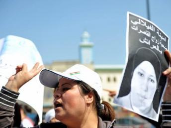 Une femme tient le portrait d’Amina El Filali lors d'un sit-in devant le tribunal local de Larache qui avait approuvé le mariage de la jeune adolescente avec son violeur, le 15 mars 2012. ABDELHAK SENNA / AFP