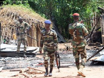Les forces armées ivoiriennes, déployées le long de la frontière avec le Liberia, patrouillent dans un village détruit. REUTERS/Luc Gnago