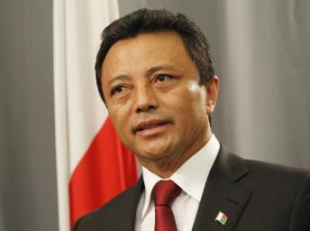 L'ex-président malgache Marc Ravalomanana brandit ses billets d'avion pour Madagascar lors d'une conférence de presse donnée à Johannesbourg, le 17 février 2011. REUTERS/Mike Hutchings