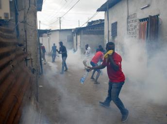 Un militant de l'UN aux prises avec les forces de l'ordre dans une rue de Libreville, le 15 août 2012. AFP PHOTO / XAVIER BOURGOIS
