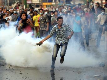 Un manifestant renvoit une canette de gaz lacrymogène vers les policiers, à proximité de l'ambassade américaine au Caire, le 13 septembre 2012.