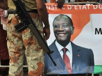 Un soldat de l'Onuci passe devant une affiche du président Alassane Ouattara.