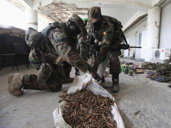 Des soldats ougandais de l'Amisom récupèrent des munitions abandonnées après la fuite des shebabs, à Mogadiscio, le 24 octobre 2012.