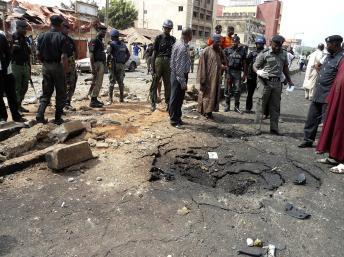 Les agents de sécurité évaluent la scène d'un attentat à la bombe du groupe islamiste Boko Haram dans la ville de Kaduna au nord du Nigeria, le 8 avril 2012