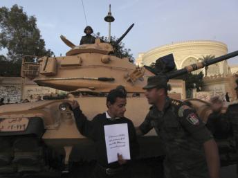 Le Caire, le 11 décembre 2012. Un officier de la Garde répubicaine demande à un manifestant anti-Morsi de s'éloigner du blindé devant lequel il se tient. REUTERS/Amr Abdallah Dalsh