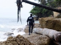 Un gendarme gabonais parcourt le rivage à la recherche d'éventuels corps.