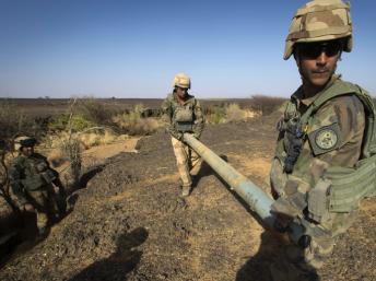 Des soldats du 92e régiment d’infanterie transportent l’une des roquettes chinoises découvertes dans la vallée située à 100 kilomètres au nord de Gao, au cours de l'opération «Gustav». AFP PHOTO / JOEL SAGET