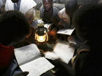 Des écoliers maliens s'éclairent à la lampe à huile. Sanogo / AFP