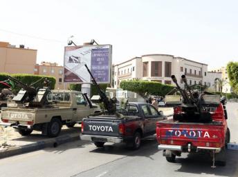 Des véhicules armés de miliciens devant le ministère des Affaires étrangères, à Tripoli, dimanche 28 avril 2013.