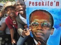 Portrait d'Aristide en main, les partisans de l'ancien président haïtien sont venus manifester aux portes du tribunal, Port-au-Prince, le 8 mai 2013.