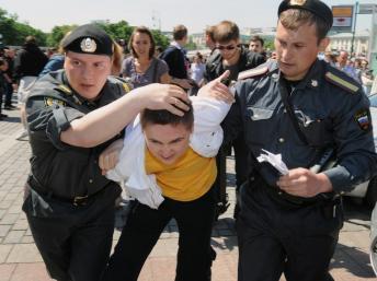 A Moscou, un manifestant homosexel malmené par deux policiers.