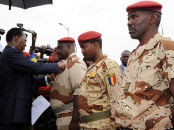 Le président tchadien Idriss Deby Itno (G) décore le général du contingent tchadien au Mali Oumar Bikimo (G) et le commandant en second Mahamat Idriss Déby Itno, le fils du président tchadien (C) lors de la cérémonie de bienvenue. Njamena, le 13 mai 2013. AFP PHOTO / STR