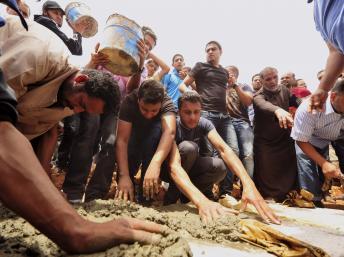 Des proches des victimes de l’explosion de lundi à Benghazi, lors des funérailles, ce mardi 14 mai. REUTERS/Esam Al-Fetori