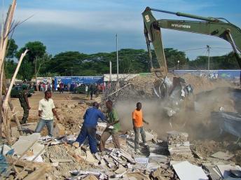 Une pelleteuse s'active dans les décombres de l'immeuble, à Nyagatare, le 15 mai 2013. AFP PHOTO /Stephanie Aglietti