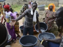Des gens font la queue avec des seaux pour prendre un peu d'eau d'une source communale à Dakar, le 27 septembre 2013. REUTERS/Ricci Shryock