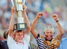 Nelson Mandela exulte après avoir remis la Coupe d'Afrique des nations de football au capitaine sud-africain Neil Tovey (en gauche).