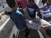 Un blessé transporté après les tirs d'une milice contre la foule venue demander son départ, le 15 novembre 2013 à Tripoli, en Libye. REUTERS/Stringer