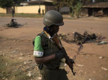 Un soldat de la Misca lors d'une patrouille à Bangui, passe devant les corps calcinés de deux musulmans tués par une foule hostile, dimanche 26 janvier à Bangui. REUTERS/Siegfried Modola