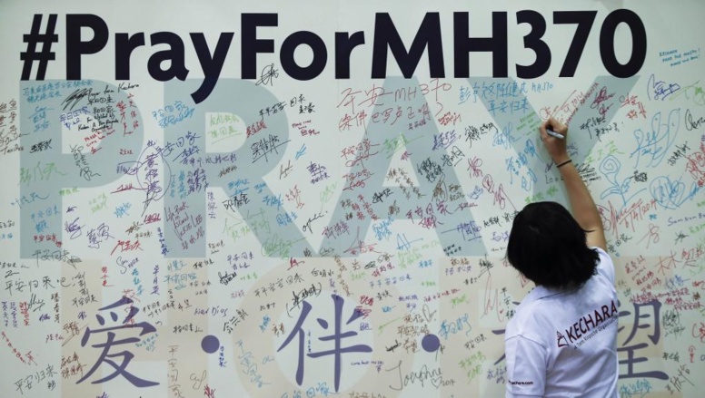 Ne pas oublier les passagers et membres d'équipage du vol MH370 de la Malaysia Airlines : les habitants de Kuala Lumpur laissent des messages sur ce mur du souvenir improvisé au siège de l'Association sino-malaisie.
