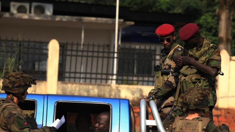 Des militaires français fouillent un véhicule alors que des soldats Seleka surveillent, à Bangui, le 23 décembre 2013.