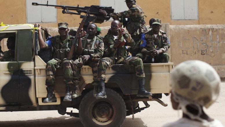 Une patrouille de militaires maliens passe devant des civils. REUTERS/Joe Penney