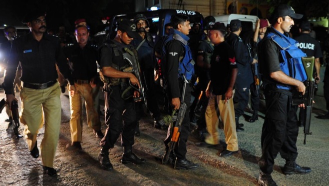 Des membres des forces de sécurité rassemblés à l'extérieur de l'aéroport de Karachi après l'attaque menée contre cet aéroport par des hommes lourdement armés, dimanche 8 juin 2014.