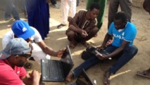 Des jeunes munis d'un ordinateur aident les électeurs à trouver leur bureau de vote, moyennant 100 ouguiyas soit environ 25 centimes d'euros. Marie-Pierre Olphand