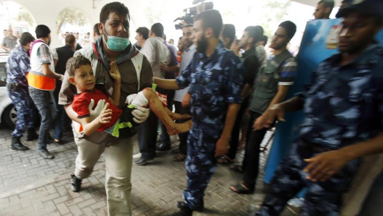 Un Palestinien transporte un enfant blessé dans le bombardement du quartier de Chajaya, à l'hôpital de Gaza-Ville, ce dimanche 20 juillet. REUTERS/Suhaib Salem