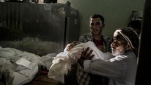 Au total, 132 enfants auraient été tués depuis le début de l'offensive israélienne dans la bande de Gaze. Ici le corps d'un enfant est remis à un parent, à Beit Lahia, le 23 juillet 2014.