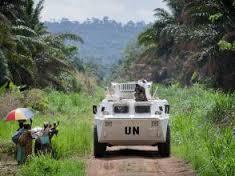Des membres de la population locale saluant le passage d’un véhicule blindé de transport de troupes de la Monusco qui se dirige vers la ligne de front, dans la région de Beni, province du Nord-Kivu en RDC, le 13 mars 2014.
