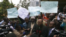 Le pasteur Martin Ssempa (C), entouré de militants anti-gays, s'exprime devant la presse, après que la Cour constitutionnelle a annulé des lois anti-gays, le 1er août 2014.