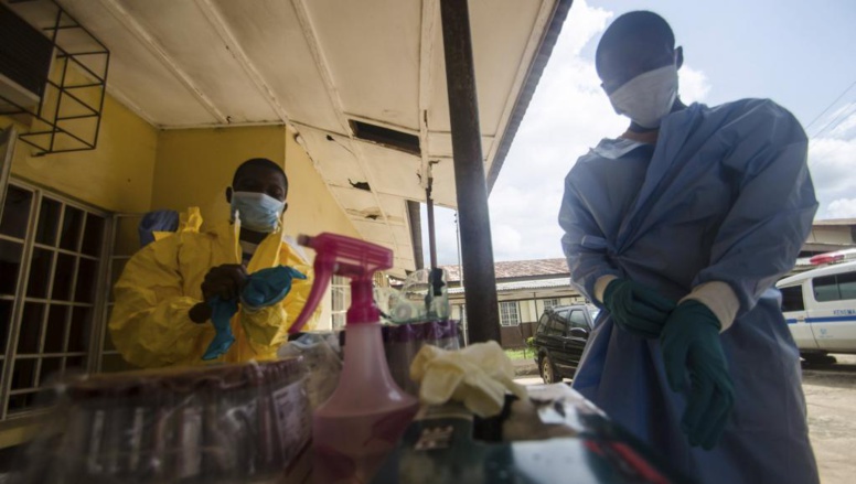 Du personnel médical se protège avant de prélever un patient suspecté d'être porteur du virus Ebola, à Kenema, en Sierra Leone.