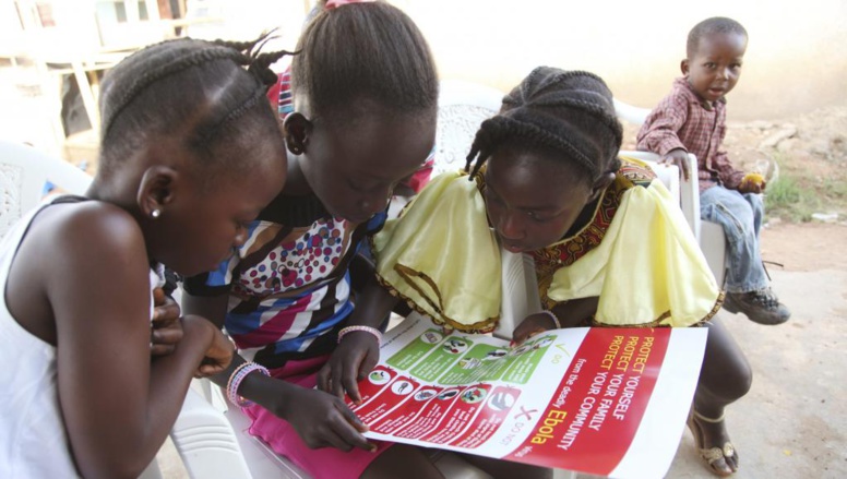 Au Liberia, des enfants lisent les documents sur l'Ebola distribués par l'Unicef. Unicef