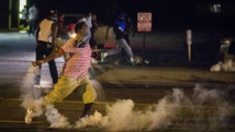 Un manifestant renvoie une grenade lacrymogène envoyée par les forces de l'ordre, à Ferguson, ce dimanche soir à quelques heures du couvre-feu (5h00 TU) REUTERS/Lucas Jackson