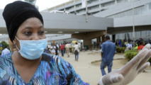 Une femme portant masque et gant de protection à l’aéroport de Murtala Muhammed de Lagos avant la confirmation d’un troisième cas Ebola dans le pays.
