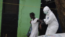 A Monrovia, au Liberia, une femme suspectée d'être atteinte du virus d'Ebola est accompagnée par un soignant vers une ambulance, le 15 septembre 2014.