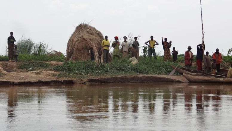 Des habitants se tiennent sur les bordsde la rivière Kagera où plusieurs corps ont été retrouvés. AFP PHOTO/ESDRAS NDIKUMANA