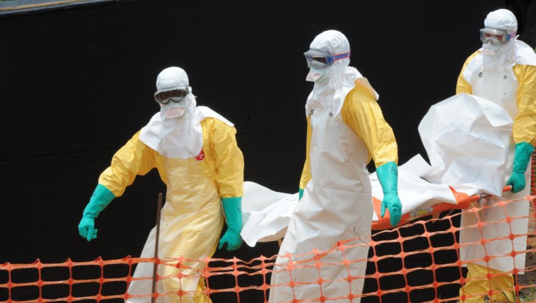 Les personnels de Médecins sans frontières portent le corps d'une personne décédée du virus Ebola, le 1er avril 2014 à Guekedou, en Guinée, dans un centre pour victimes de la fièvre hémorragique. AFP/ SEYLLOU